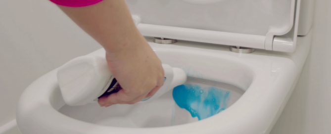 Participant using a cleaning product on a toilet for liquid fragrance research project