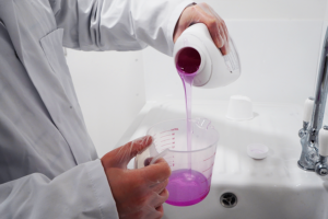 A Sense:lab Fieldwork Executive decants a cleaning product into a measuring jug